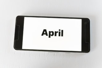 April travel planning concept showing the word April on a smartphone screen