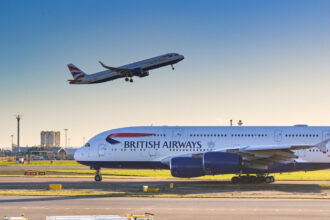 British Airways Airbus A380 on the runway with aircraft departing in the background
