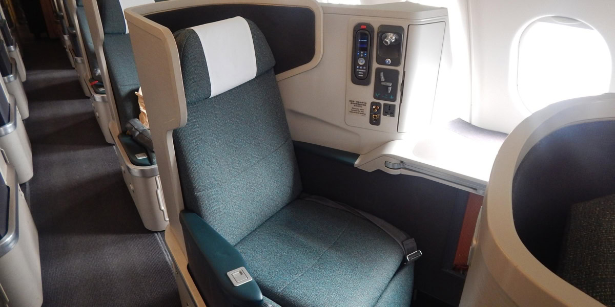 Business class airline seat showing upgraded cabin with lie flat seat and window view