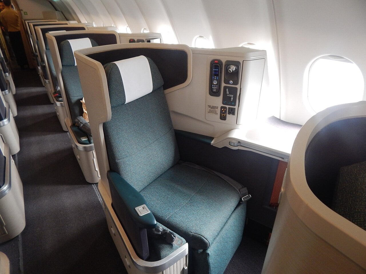 Business class airline seat showing upgraded cabin with lie flat seat and window view
