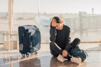 Passenger sitting on airport floor after being denied boarding for a flight