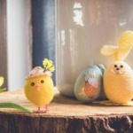 Easter decorations with chick, bunny and eggs beside spring flowers