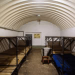 Civil defence bomb shelter interior with bunk beds and reinforced ceiling