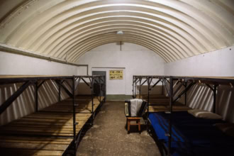 Civil defence bomb shelter interior with bunk beds and reinforced ceiling