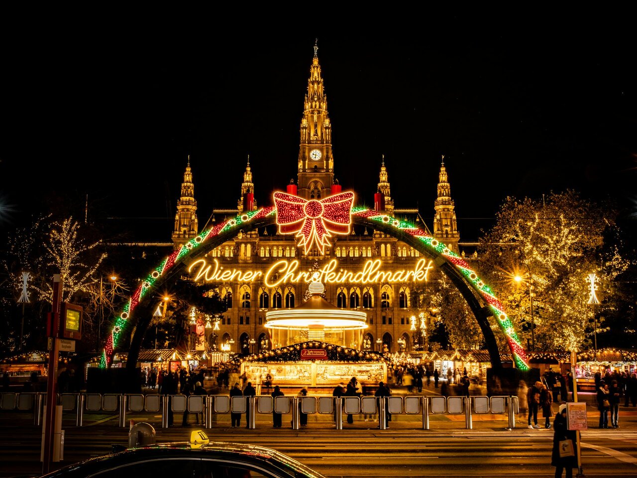 Vienna Christmas market at night in front of Rathaus with festive lights and decorations