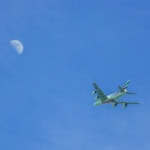 Emirates aircraft flying in blue sky during long haul flight suitable for airline stopover programmes