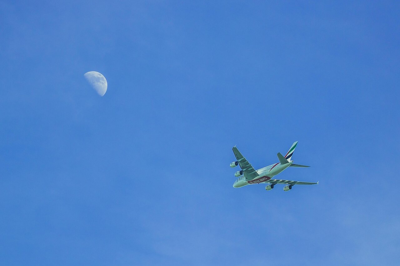 Emirates aircraft flying in blue sky during long haul flight suitable for airline stopover programmes