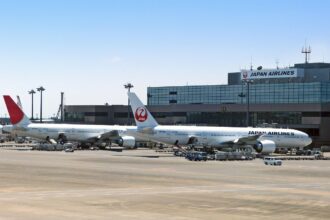 Japan Airlines aircraft parked at Tokyo airport terminal with JAL branding