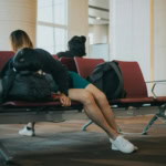 Traveller sleeping in airport terminal due to jet lag and travel fatigue