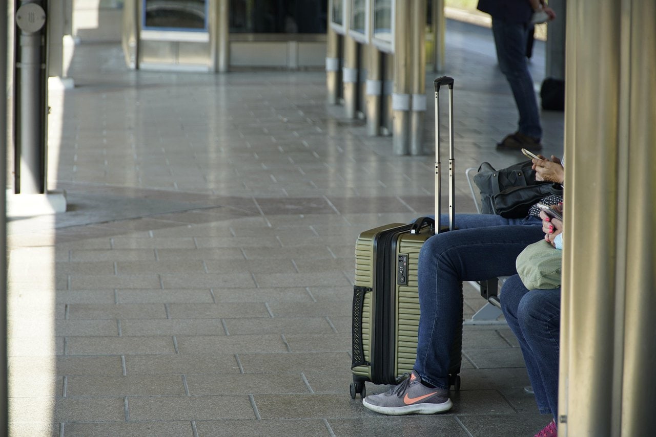 Luggage storage travel โ travellers sitting with suitcases at a train station