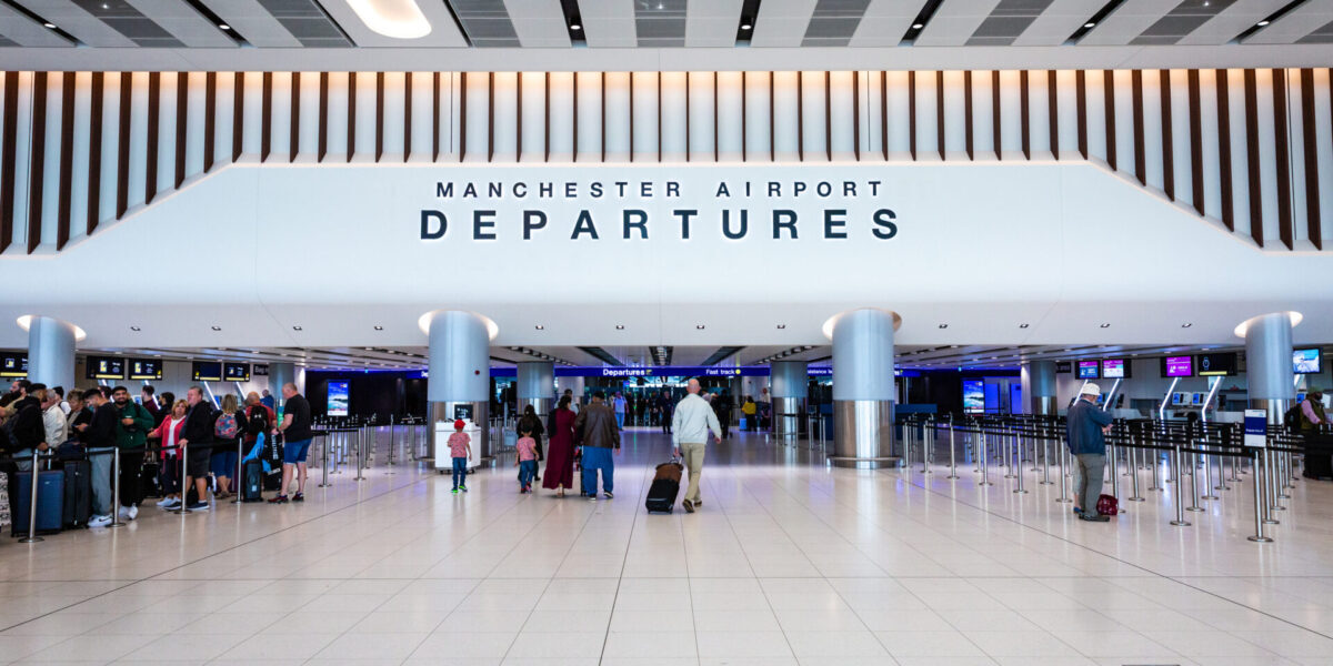 Manchester Airport departures hall showing travellers preparing for flights across Europe