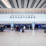 Manchester Airport departures hall showing travellers preparing for flights across Europe