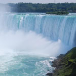 Boat approaching Horseshoe Falls at Niagara Falls with mist and powerful cascading water
