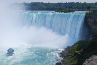 Boat approaching Horseshoe Falls at Niagara Falls with mist and powerful cascading water