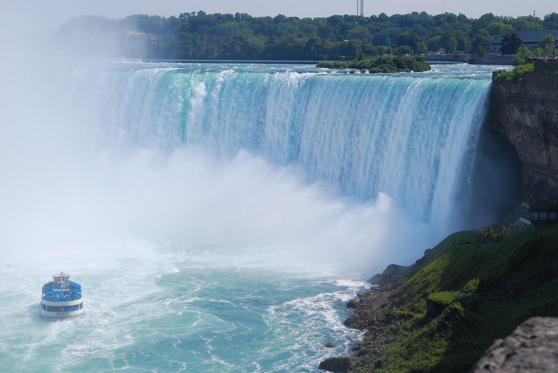 Boat approaching Horseshoe Falls at Niagara Falls with mist and powerful cascading water