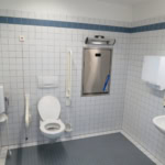 Accessible public toilet with wheelchair grab rails and baby changing station
