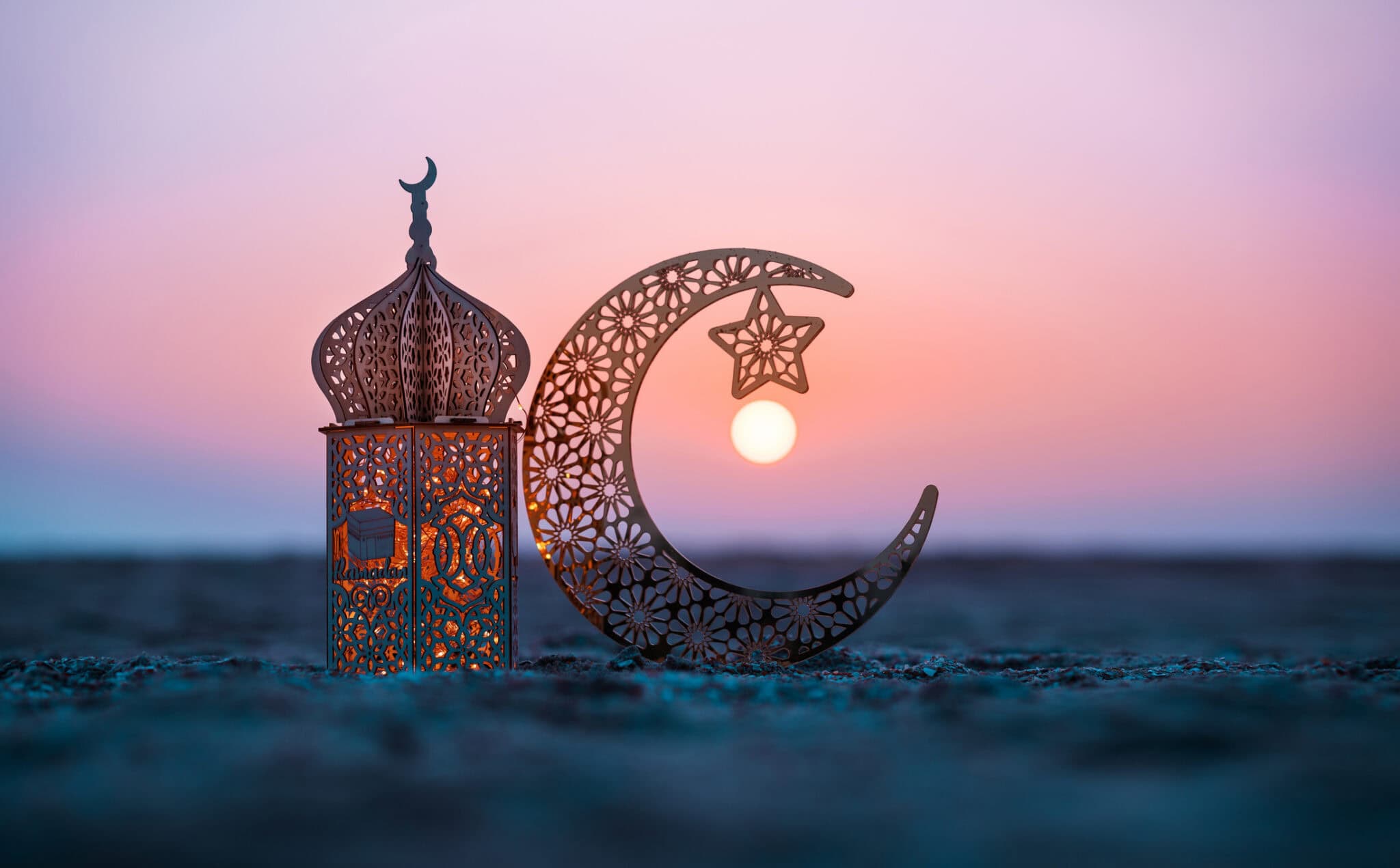 Travel during Ramadan: traditional lantern and crescent moon at sunset