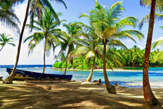 San Blas Islands Panama tropical beach with palm trees and wooden boat
