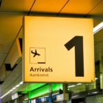 Airport arrivals sign inside terminal for passengers collecting baggage during self transfer