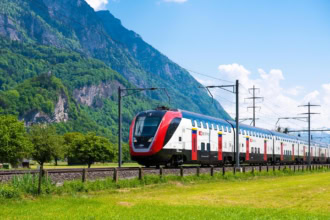 Swiss SBB train travelling through the Alps with mountains and greenery, Switzerland rail travel example