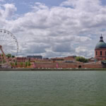 Toulouse riverfront with Ferris wheel and historic buildings near Garonne River