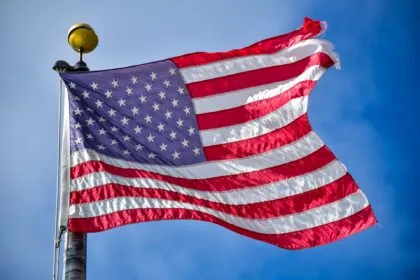 American flag flying against blue sky representing travel to the United States