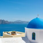 Santorini blue dome church overlooking caldera Greece
