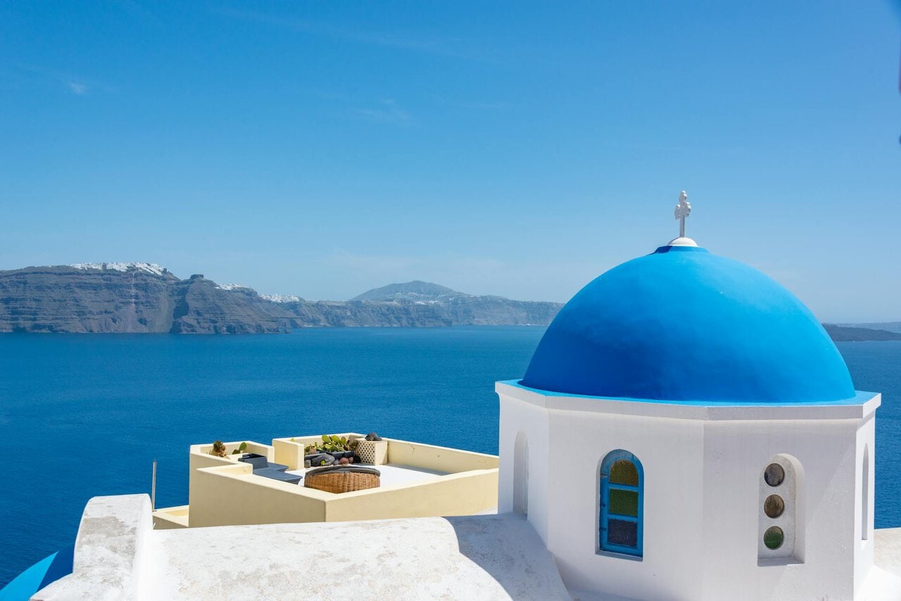 Santorini blue dome church overlooking caldera Greece