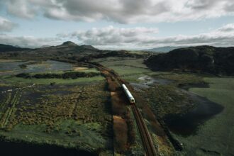 Cambrian line train crossing estuary landscape in Snowdonia Wales