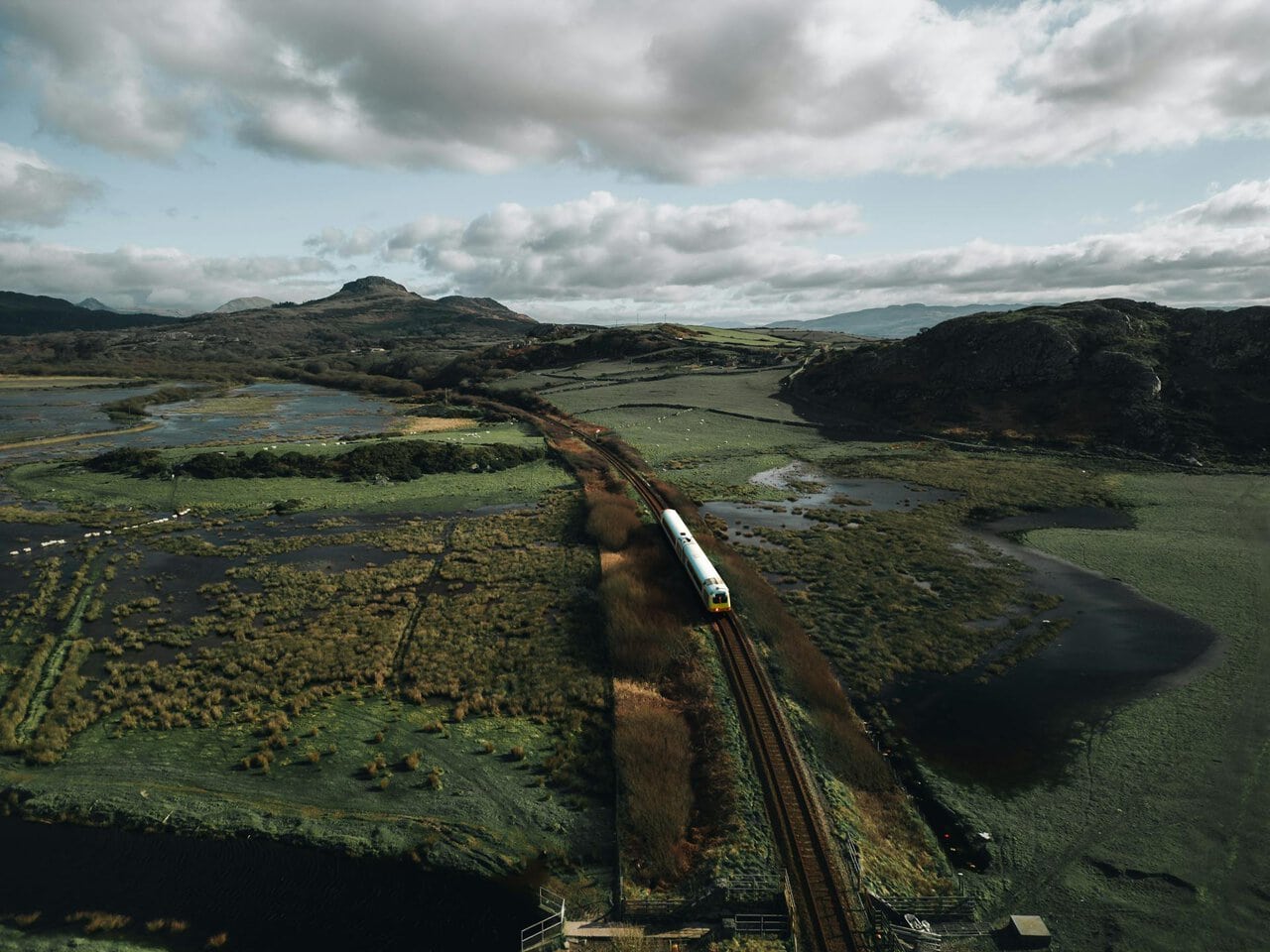 Cambrian line train crossing estuary landscape in Snowdonia Wales