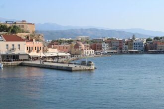 Chania Venetian harbour waterfront with historic buildings and mountains in Crete Greece