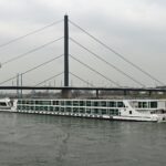 Düsseldorf Rhine river cruise boat passing under bridge with city skyline