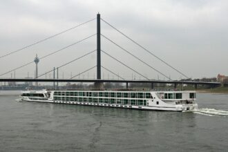 Düsseldorf Rhine river cruise boat passing under bridge with city skyline