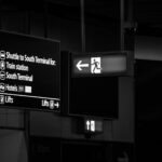 Signage inside Gatwick Airport terminal showing directions to train station and South Terminal