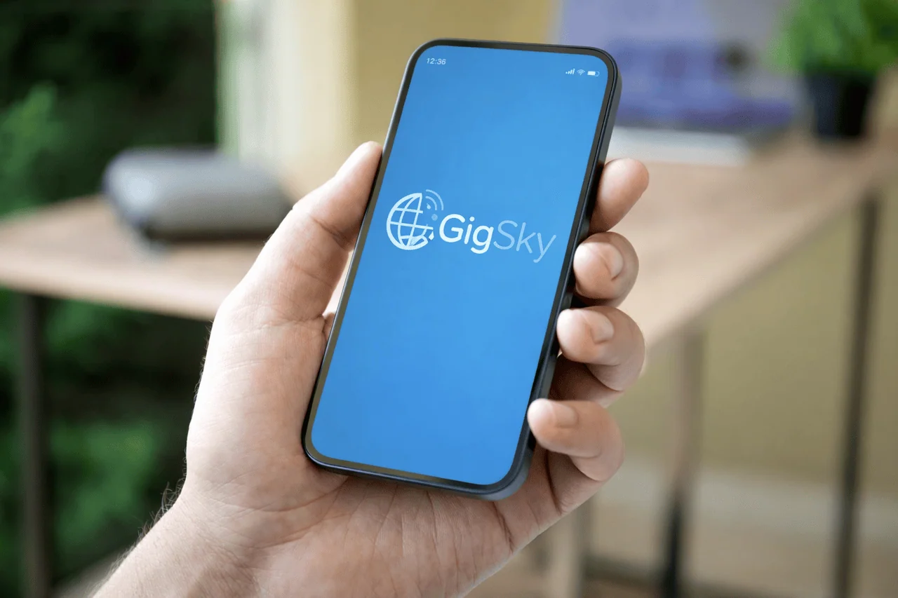 Smartphone displaying the GigSky eSIM app on screen while being held in a hand indoors