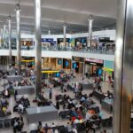 Passengers waiting inside Heathrow Airport terminal departure hall
