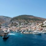 Hydra harbour with ferry arriving and hillside town Greece