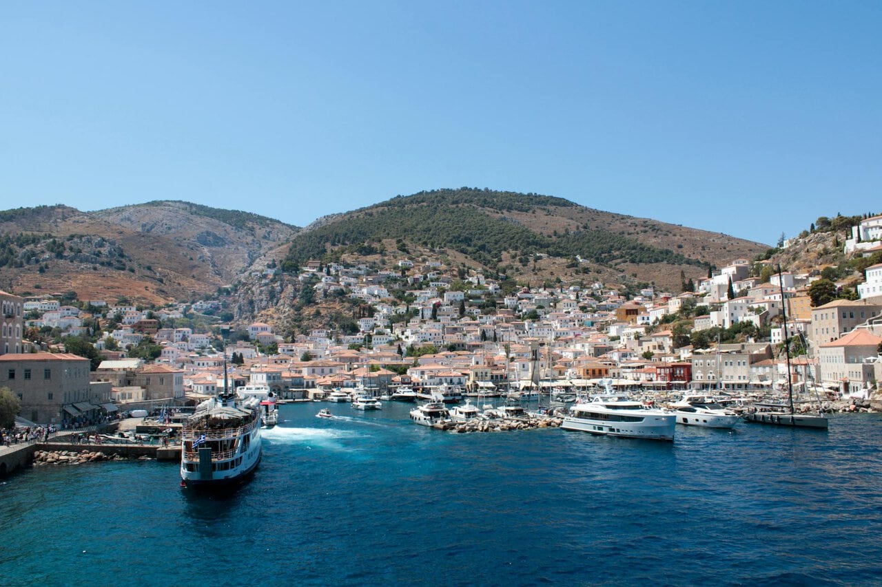 Hydra harbour with ferry arriving and hillside town Greece