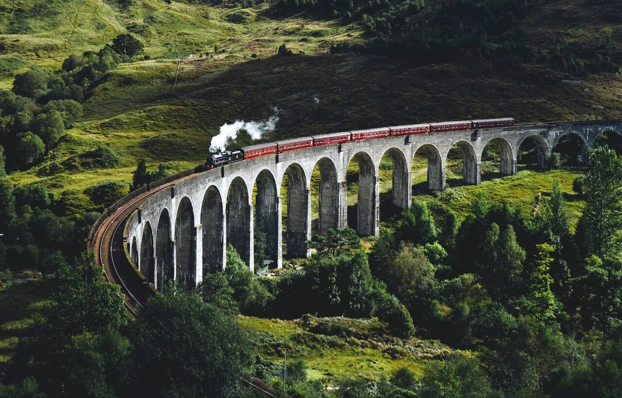 Jacobite Steam Train crossing Glenfinnan Viaduct in Scotland Harry Potter filming location