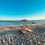 Kos beach with sunbeds and parasol overlooking the Aegean Sea in Greece