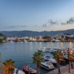 Kos Town harbour at sunset with boats, waterfront and palm trees in Greece