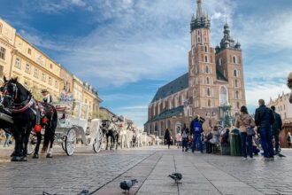 Kraków Main Market Square with St Mary's Basilica and horse carriages