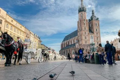 KrakĂłw Main Market Square with St Mary's Basilica and horse carriages