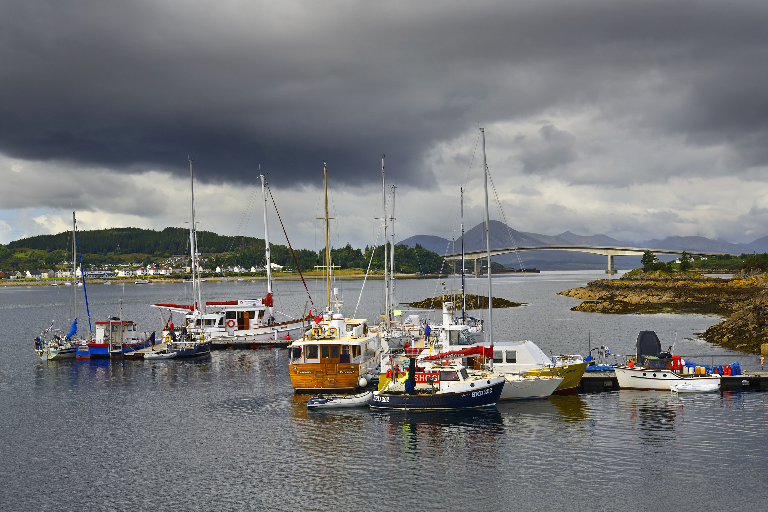 Kyle of Lochalsh harbour with boats and the Skye Bridge in the Scottish Highlands