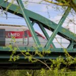 LNER train crossing a green steel bridge on the East Coast Main Line in the UK