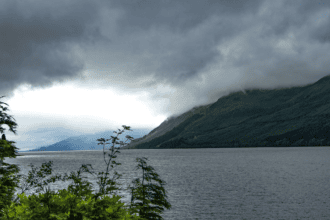 Loch Ness in the Scottish Highlands with low cloud over the hills and dark water