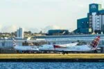 Loganair aircraft on runway at UK airport with terminal in background