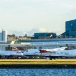 Loganair aircraft on runway at UK airport with terminal in background
