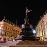 Eros statue at Piccadilly Circus London at night with illuminated buildings