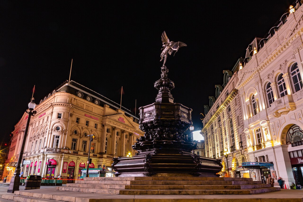 Eros statue at Piccadilly Circus London at night with illuminated buildings